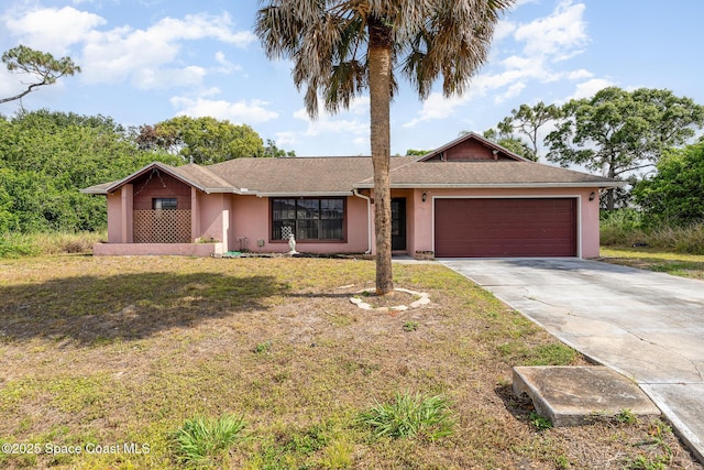 ranch-style house with stucco siding, an attached garage, driveway, and a front yard