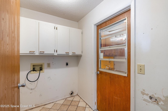 clothes washing area with hookup for an electric dryer, cabinet space, hookup for a washing machine, a textured ceiling, and light tile patterned flooring