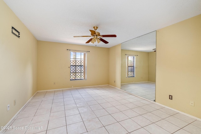 spare room with ceiling fan and baseboards