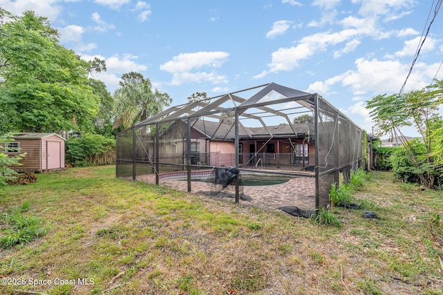 rear view of house featuring a shed, an outbuilding, glass enclosure, and a patio