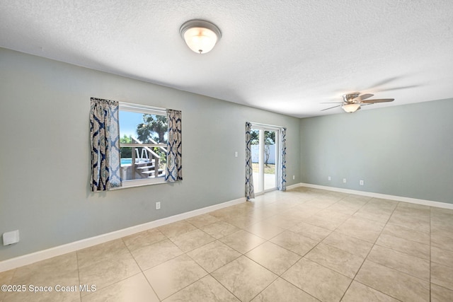 unfurnished room featuring light tile patterned floors, baseboards, ceiling fan, and a textured ceiling
