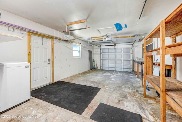 garage featuring a garage door opener and washer / dryer