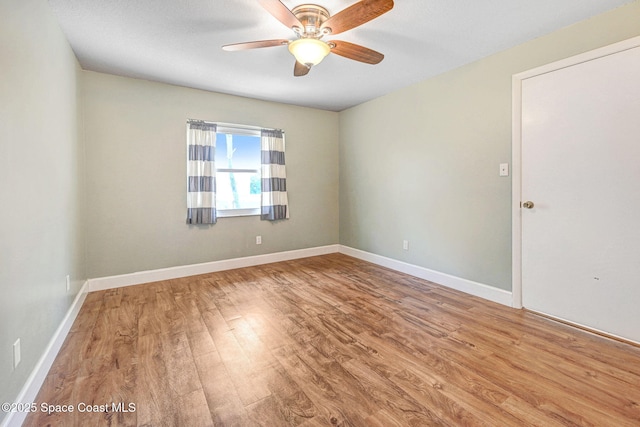 unfurnished room with baseboards, a ceiling fan, and wood finished floors