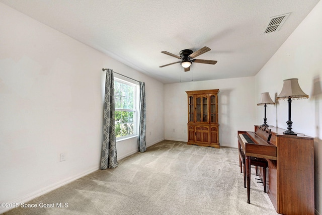 interior space with baseboards, a ceiling fan, and visible vents