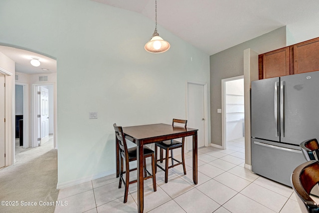 dining space with baseboards, high vaulted ceiling, light tile patterned floors, and visible vents