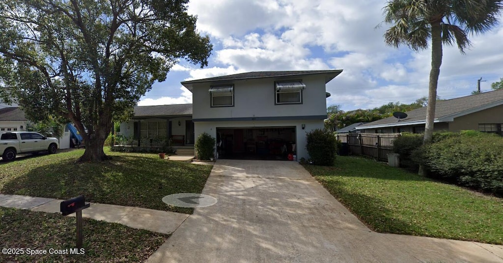 view of front of house featuring driveway, fence, a front yard, stucco siding, and a garage