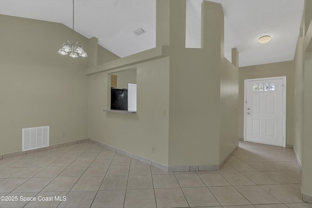 entryway with visible vents, baseboards, high vaulted ceiling, light tile patterned floors, and a notable chandelier