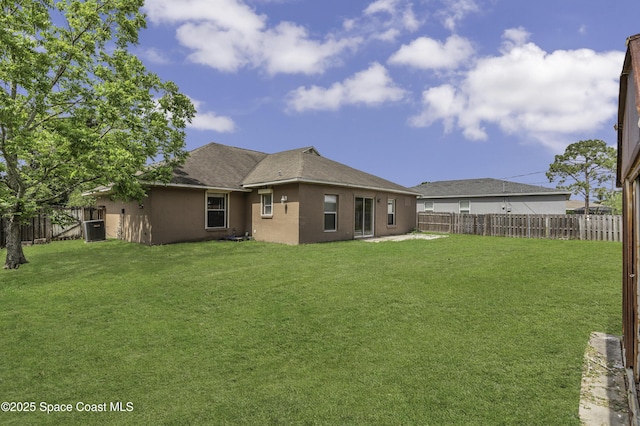 rear view of property with a fenced backyard, central AC unit, and a lawn
