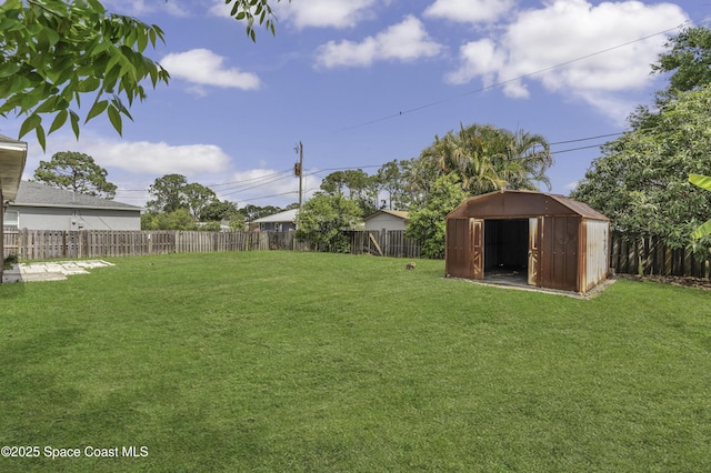 view of yard with an outbuilding, a fenced backyard, and a storage unit