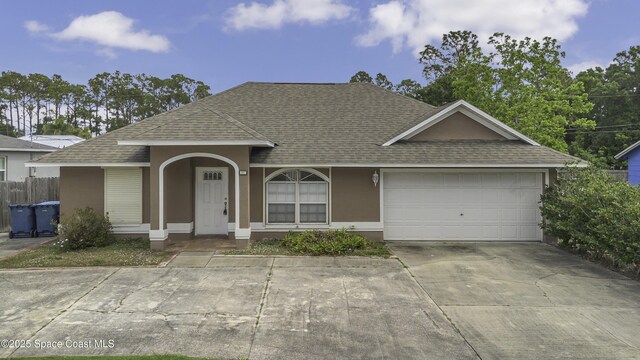 ranch-style home with an attached garage, roof with shingles, and stucco siding