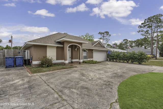 ranch-style house featuring fence, roof with shingles, stucco siding, concrete driveway, and an attached garage