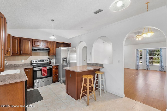 1500 Gardenton St NW Unit 44, Palm Bay, FL 32907 - kitchen with stainless steel appliances, a sink, under cabinet range hood, lofted ceiling, and arched walkways