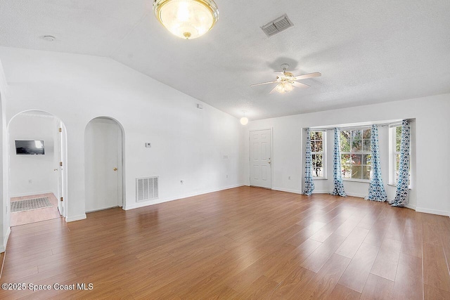 1500 Gardenton St NW Unit 44, Palm Bay, FL 32907 - unfurnished living room with ceiling fan, wood finished floors, lofted ceiling, baseboards, and arched walkways