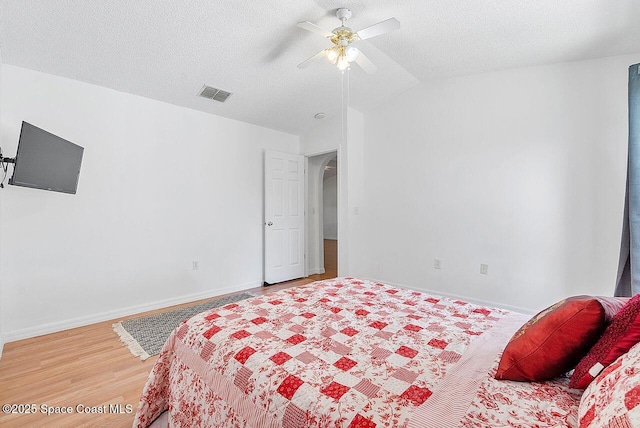 1500 Gardenton St NW Unit 44, Palm Bay, FL 32907 - bedroom featuring light wood-style floors, vaulted ceiling, baseboards, ceiling fan, and a textured ceiling