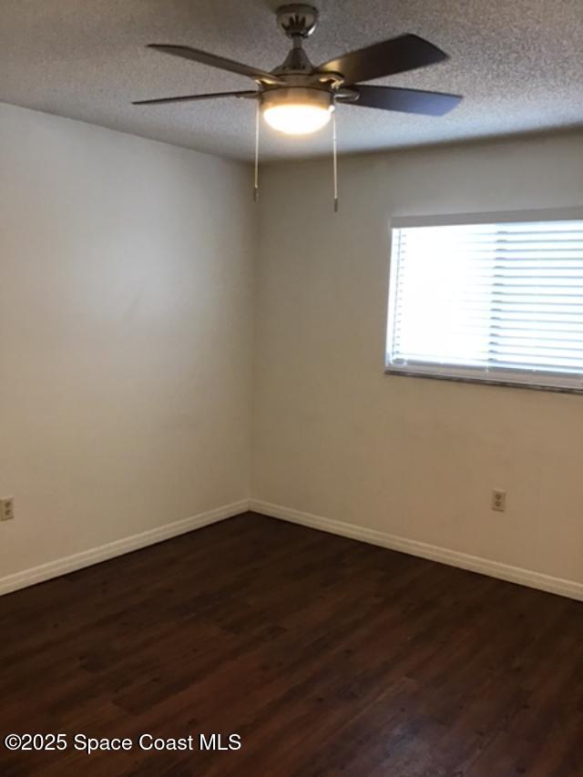 1720 Murrell Rd Unit 207, Rockledge, FL 32955 - spare room featuring baseboards, a ceiling fan, a textured ceiling, and dark wood finished floors