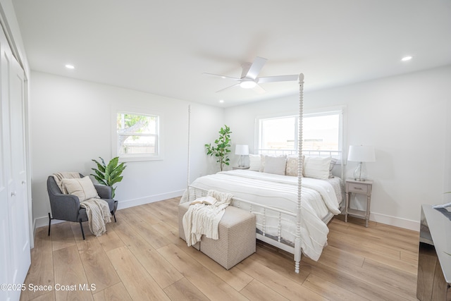 bedroom featuring baseboards, a ceiling fan, and light wood-style flooring