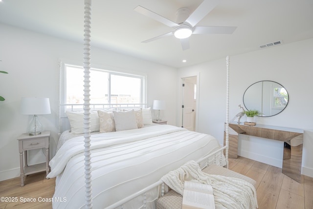 bedroom with baseboards, a ceiling fan, light wood-type flooring, and visible vents