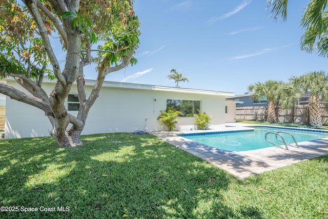 view of swimming pool featuring a lawn, fence, a patio area, and a fenced in pool