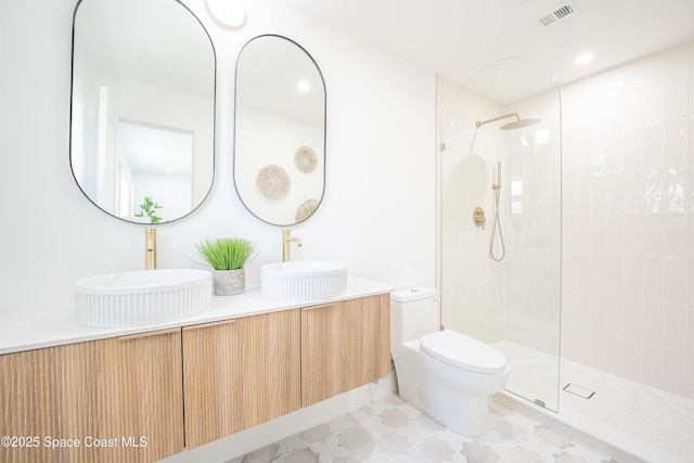 full bath featuring a sink, walk in shower, toilet, and visible vents
