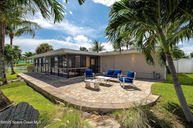 exterior space featuring outdoor lounge area, fence, a gate, and a sunroom