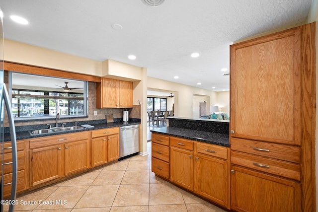 kitchen with stainless steel dishwasher, brown cabinetry, light tile patterned flooring, tasteful backsplash, and a sink