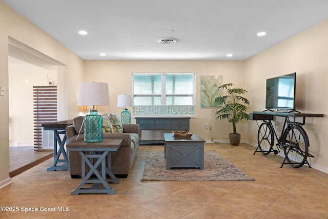 tiled living area featuring baseboards and recessed lighting