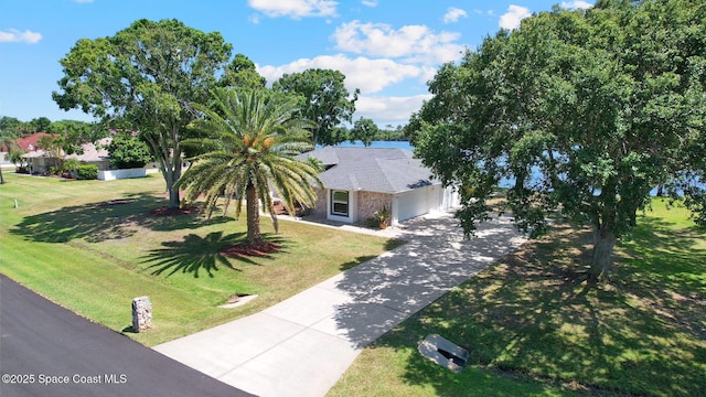 view of front of property featuring driveway, a front yard, and a garage