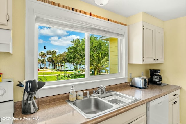 kitchen featuring white cabinets, a sink, and dishwasher