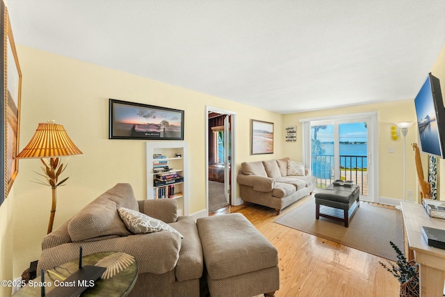 living room with baseboards and light wood-type flooring