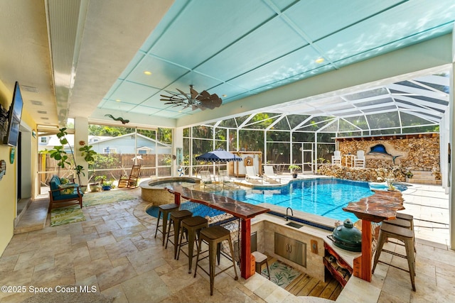 outdoor pool with fence, ceiling fan, exterior bar, a patio, and glass enclosure