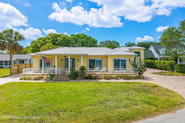 view of front of property featuring a front lawn, ceiling fan, fence, covered porch, and metal roof