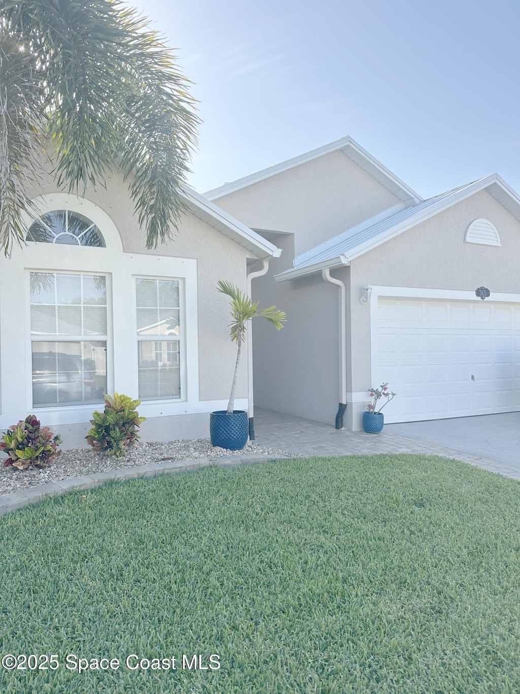single story home featuring stucco siding, concrete driveway, a front yard, and a garage