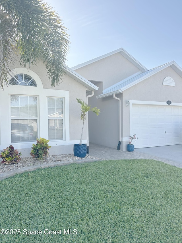 single story home featuring stucco siding, concrete driveway, a front yard, and a garage