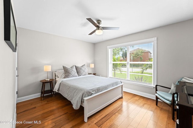 bedroom with baseboards, light wood-style flooring, and ceiling fan
