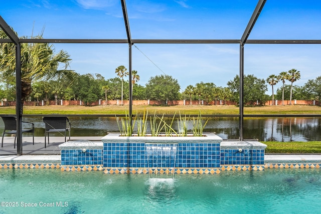 view of swimming pool featuring glass enclosure and a water view