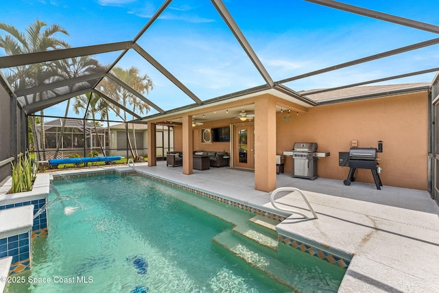 outdoor pool with area for grilling, ceiling fan, a patio area, glass enclosure, and an outdoor hangout area