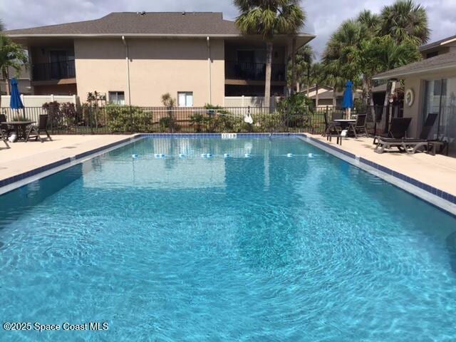 community pool featuring a patio and fence