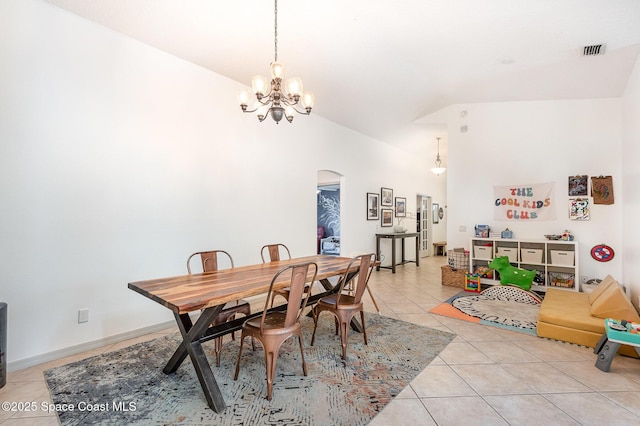 dining room with arched walkways, a chandelier, light tile patterned floors, lofted ceiling, and visible vents