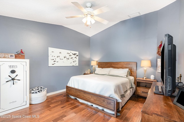 bedroom with baseboards, ceiling fan, wood finished floors, and lofted ceiling