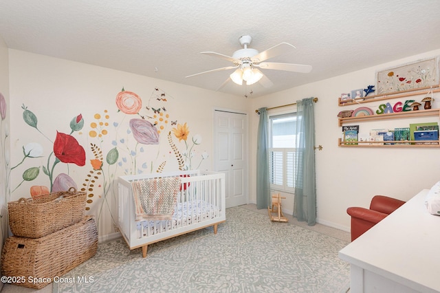 bedroom featuring a textured ceiling, baseboards, ceiling fan, and a closet