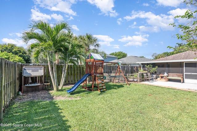 view of jungle gym featuring a yard, a patio, and a fenced backyard