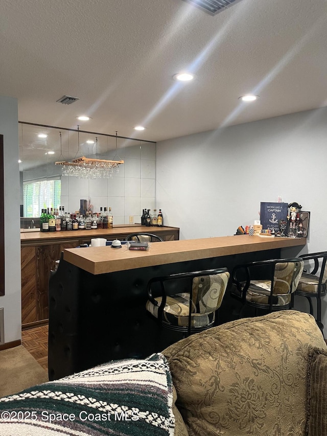 580 Hidden Creek Dr, Merritt Island, FL 32952 - bar with a textured ceiling, visible vents, a dry bar, and carpet