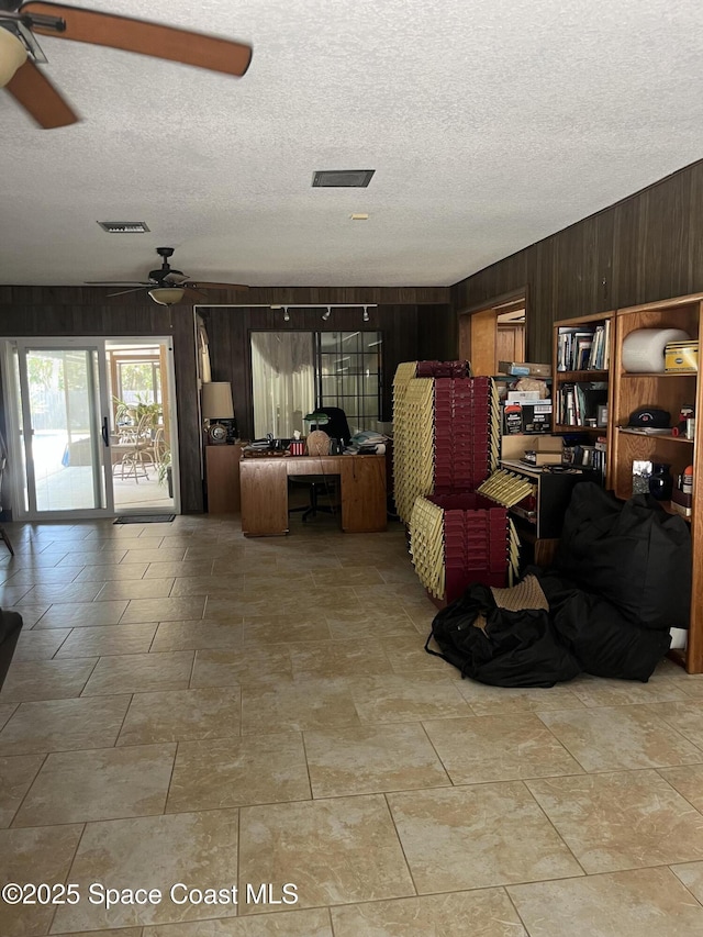 580 Hidden Creek Dr, Merritt Island, FL 32952 - living area with visible vents, a textured ceiling, ceiling fan, and wooden walls