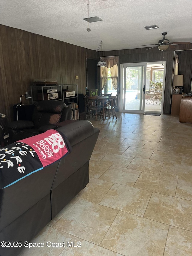 580 Hidden Creek Dr, Merritt Island, FL 32952 - living room with a textured ceiling, wood walls, and plenty of natural light