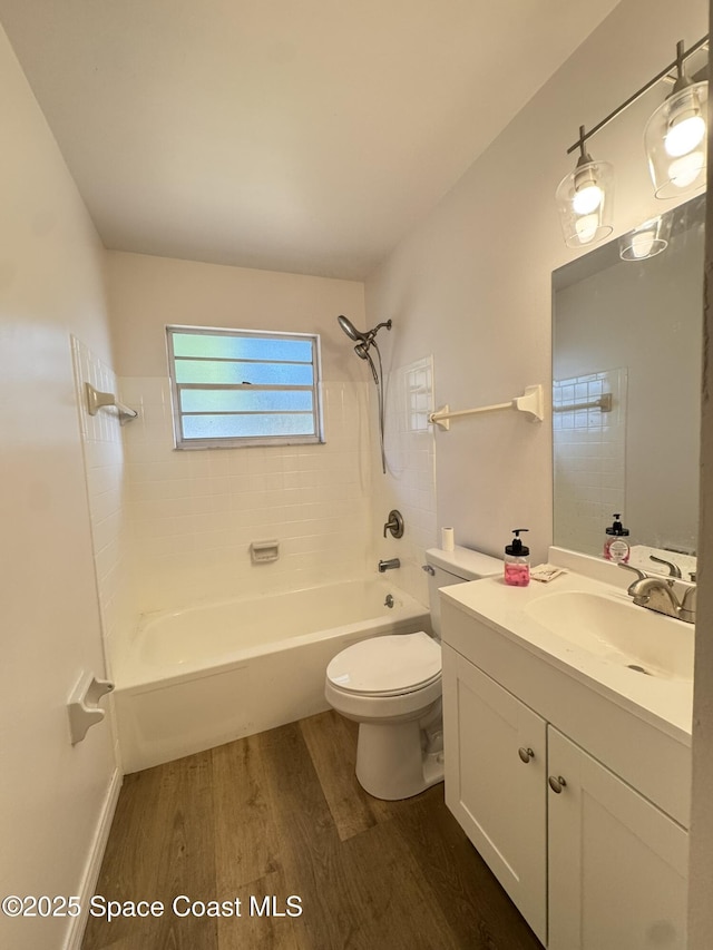 bathroom with vanity, toilet, wood finished floors, and tub / shower combination