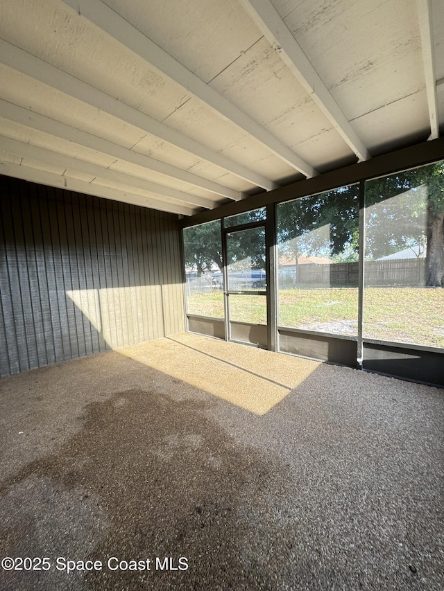 unfurnished sunroom with beam ceiling