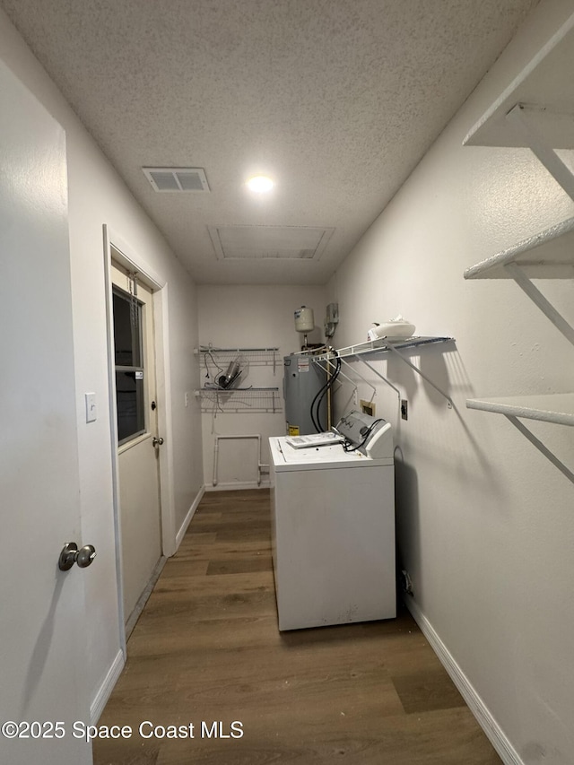 laundry room with laundry area, visible vents, wood finished floors, washer / clothes dryer, and water heater