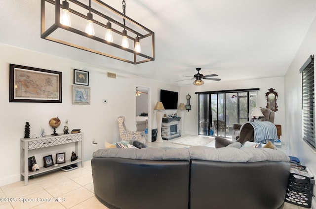 100 Canebreakers Dr Unit 112, Cocoa, FL 32927 - living area featuring light tile patterned flooring, ceiling fan, a fireplace, baseboards, and visible vents