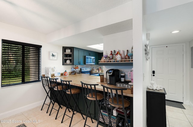 100 Canebreakers Dr Unit 112, Cocoa, FL 32927 - dining room featuring a bar, baseboards, and light tile patterned floors