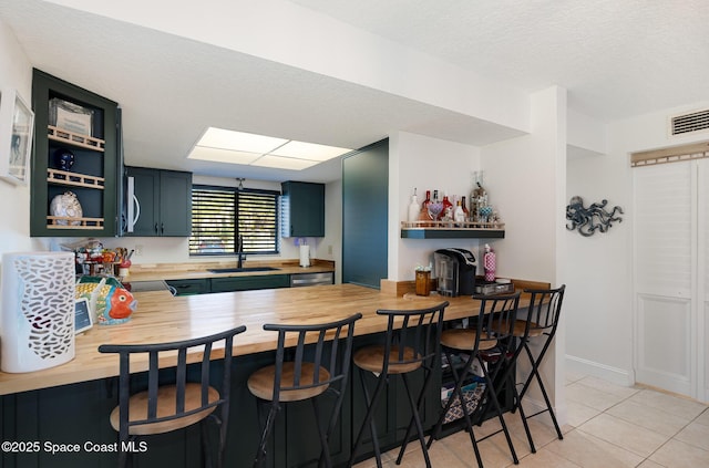100 Canebreakers Dr Unit 112, Cocoa, FL 32927 - kitchen featuring open shelves, a sink, a textured ceiling, wooden counters, and visible vents